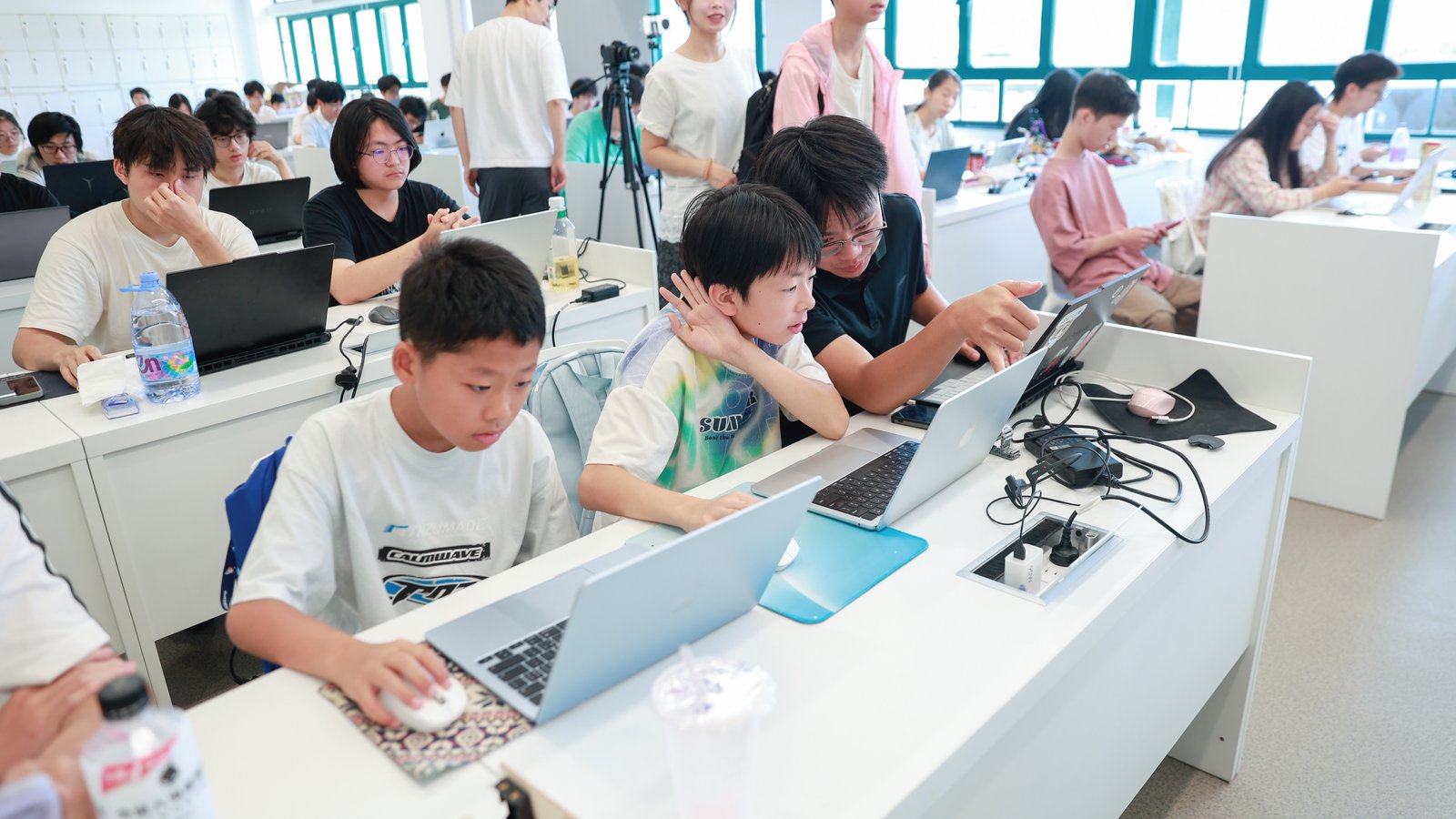 混龄工作台 · 少年 CEO 学员与浙大同学在同一间教室并肩用笔记本开发未来学习应用